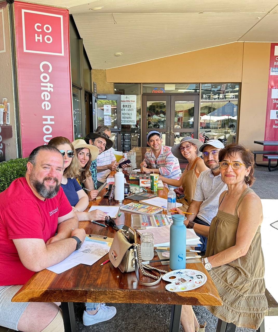 Friends gathered around art supplies at a café