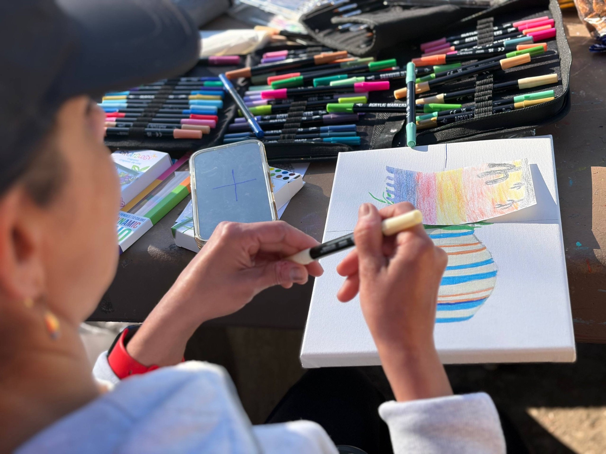 A participant drawing with colorful acrylic markers